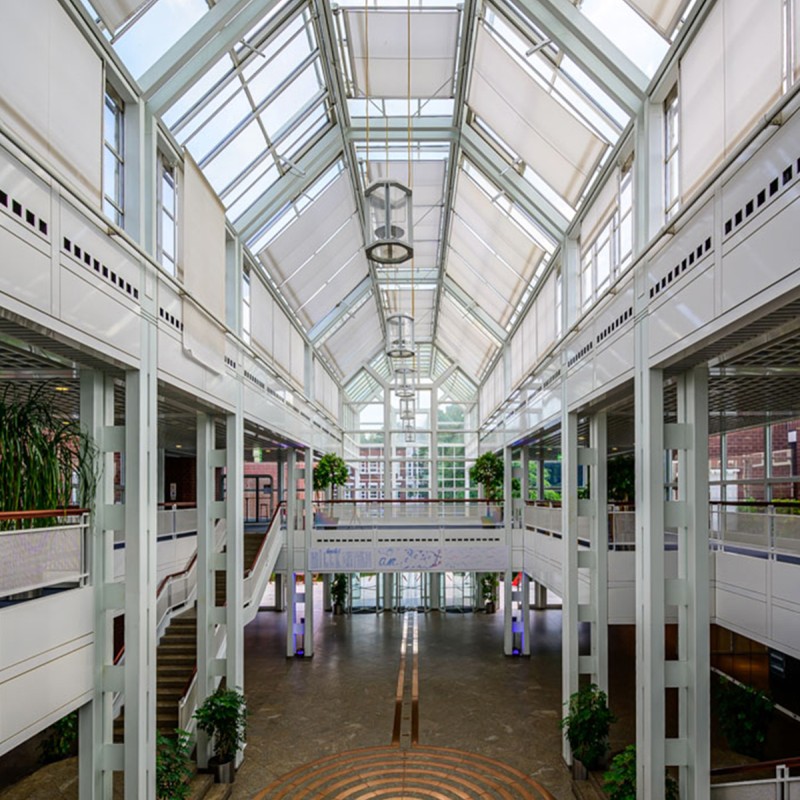 Foyer eines Gebäudes mit hoher Decke und mehreren Etagen